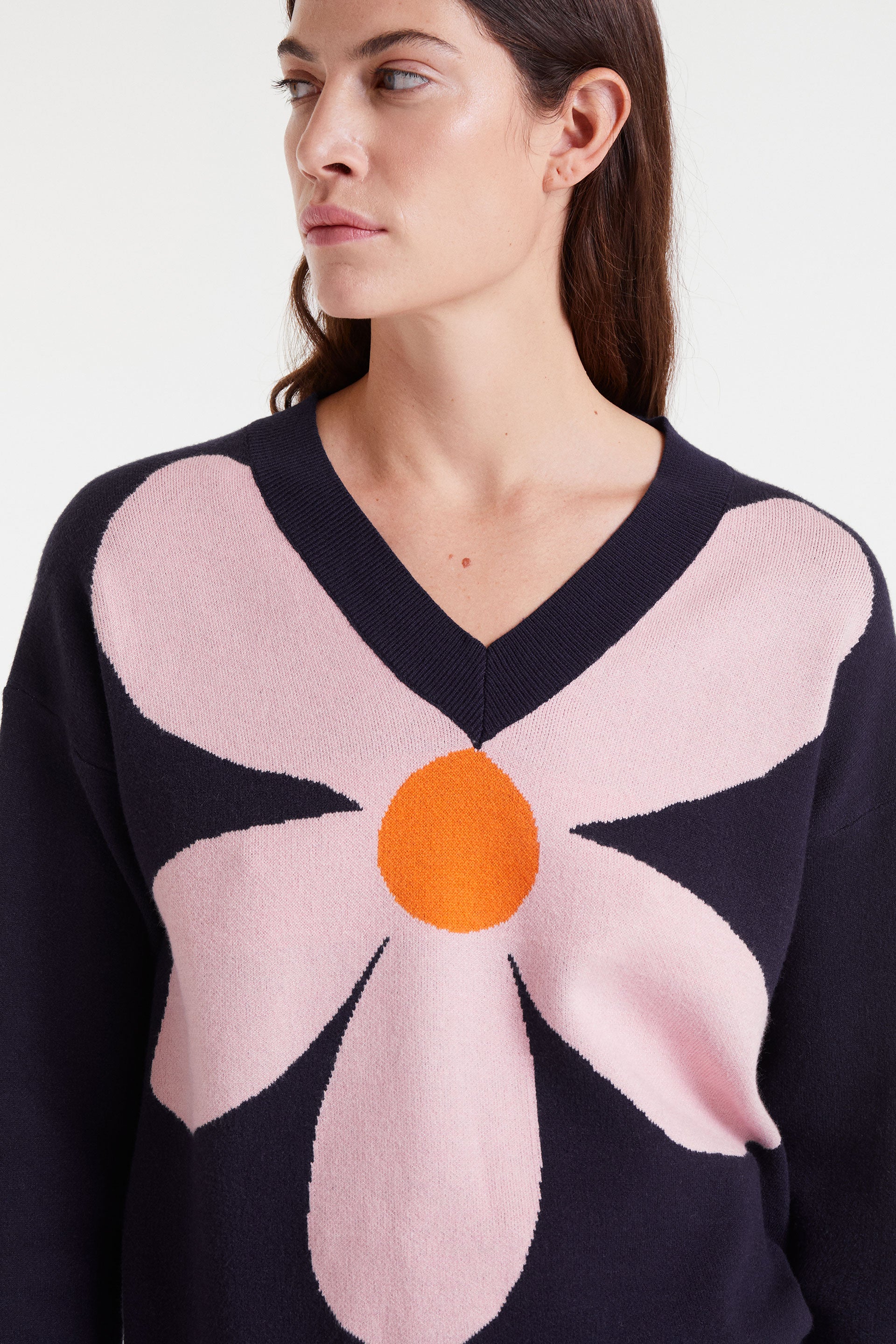 Navy blue sweater with pink flower and orange detail